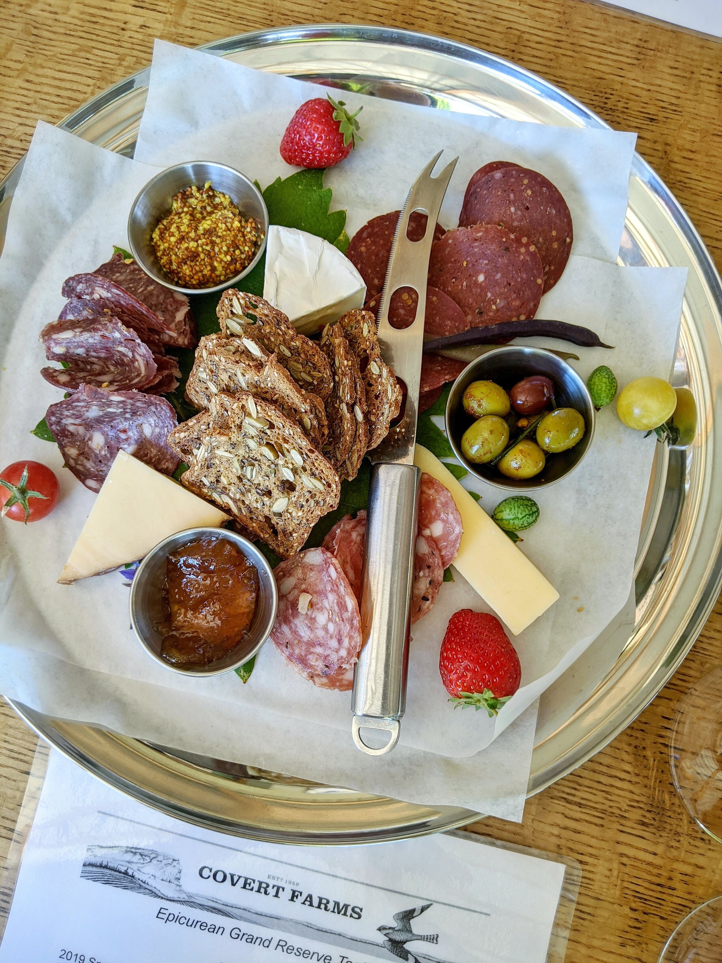 Charcutier Plate: artisanal cheeses, cured meats, olives, crackers, jam, grainy mustard and fresh produce grown on their farm.